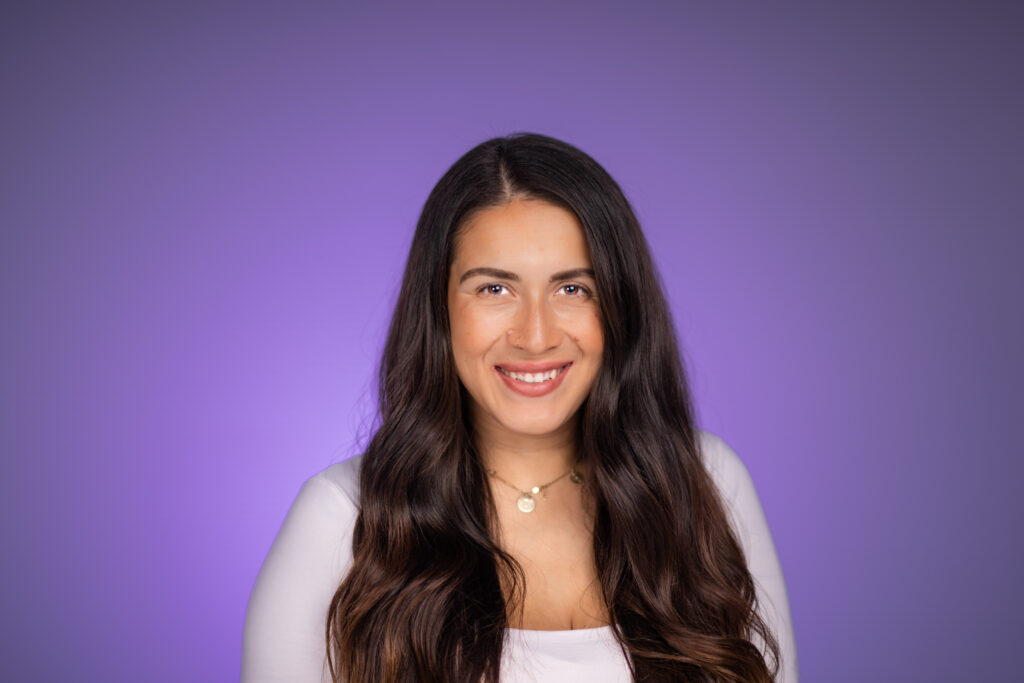 Headshot of a woman taken in studio with a purple background